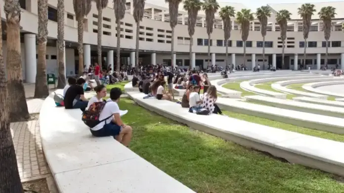 Cartell o estudiants davant d’un campus mentre comença el període de matrícula universitària