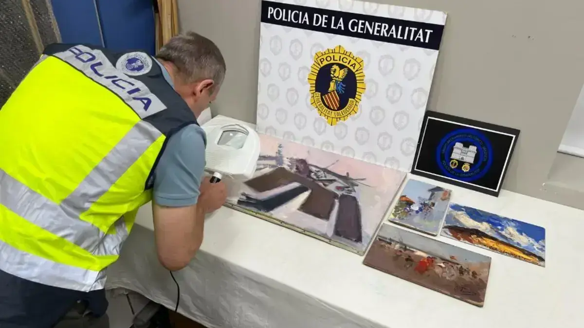 Agents de la Policia de la Generalitat al costat de quatre pintures intervingudes atribuides a artistes.