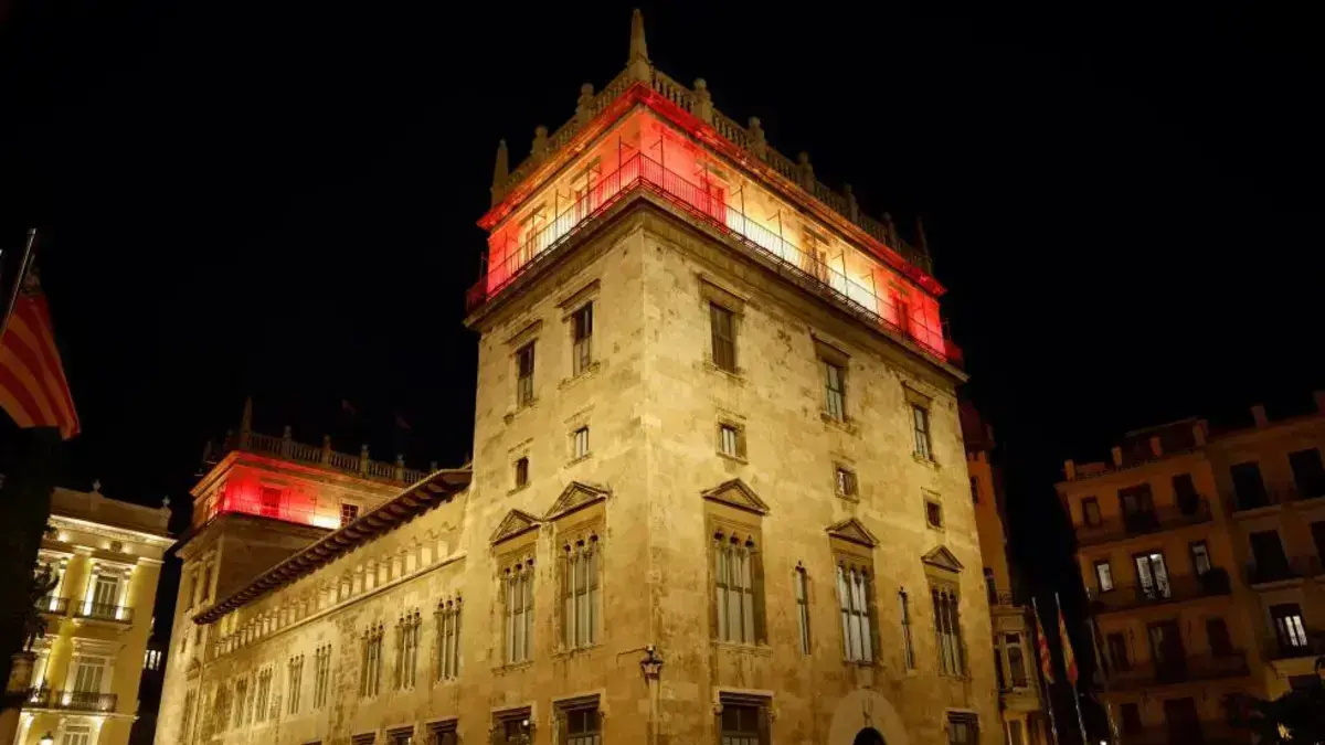 Edifici il·luminat i elements del transport públic amb els colors de la bandera d’Espanya
