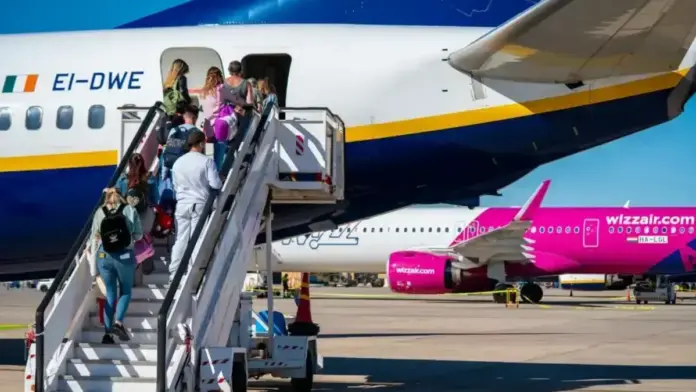 Avió i pista a l’aeroport de Castelló amb activitat de passatgers al fons.