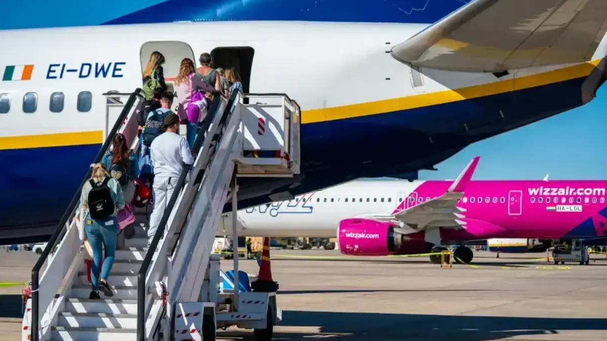 Avió i pista a l’aeroport de Castelló amb activitat de passatgers al fons.