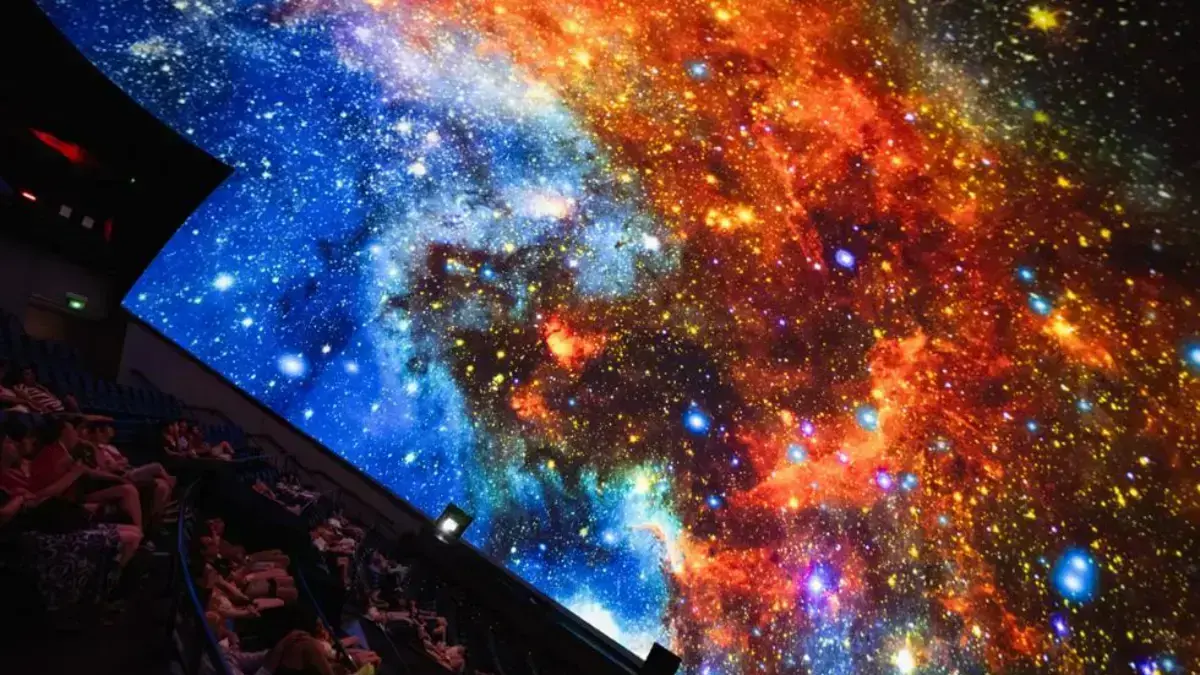 Persones a l’Hemisfèric durant una sessió del planetari en directe