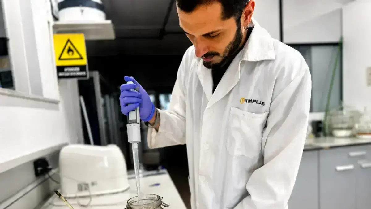 Representació de bioplàstics degradant-se en un entorn industrial amb bacteris i fagos