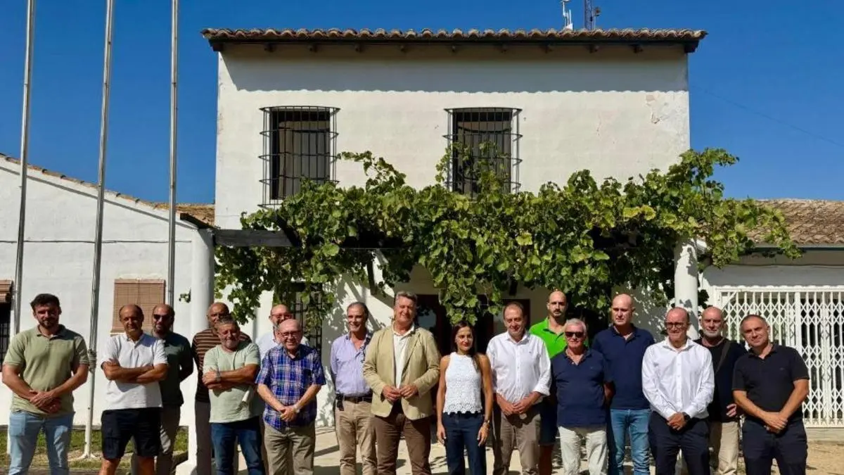 Treballadors i maquinària en un camp d’arròs, amb crema controlada per gestionar la palla.