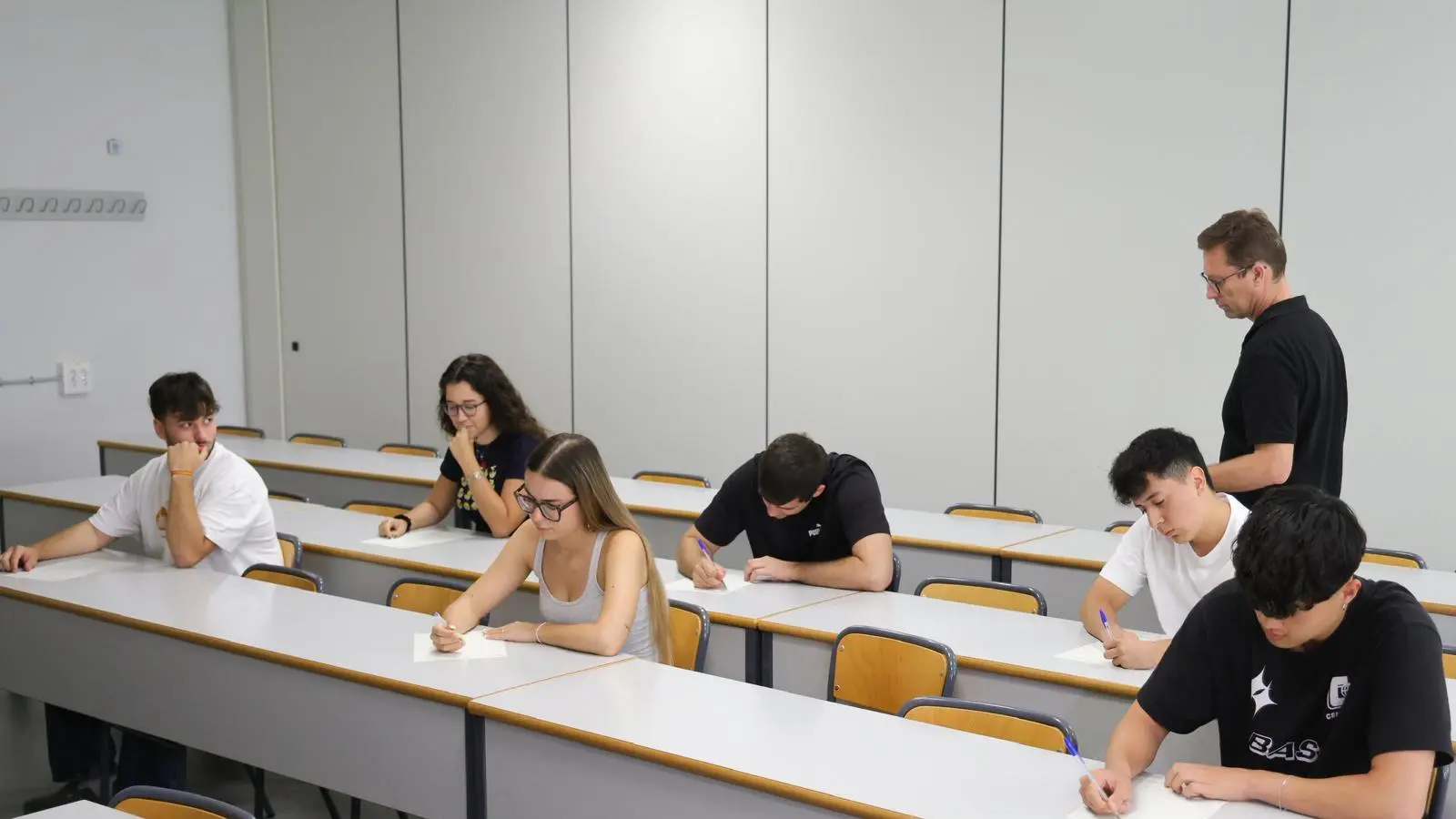 Estudiants al campus, amb informació sobre notes de tall i adjudicació de vacants.