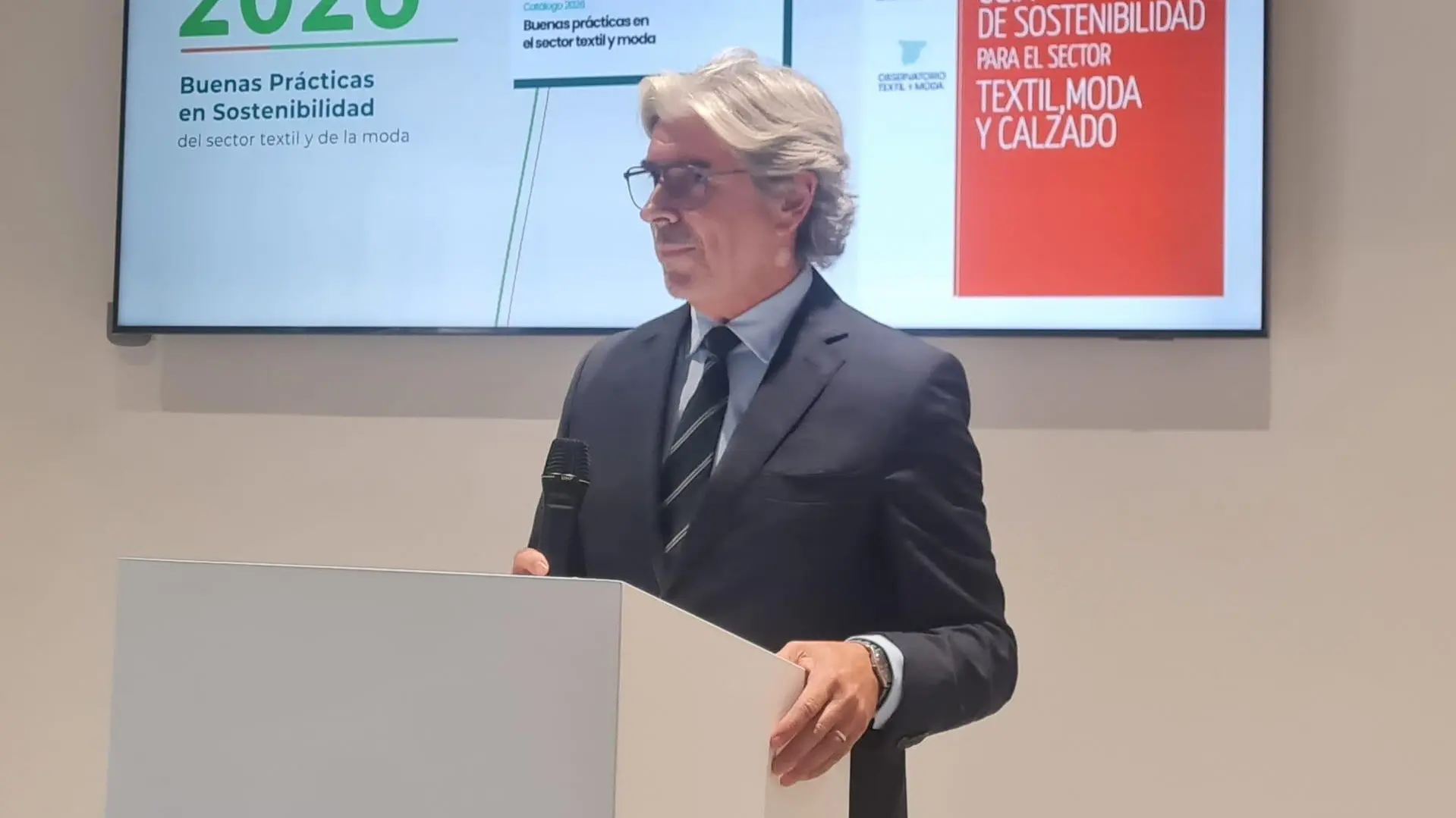 Persones en un entorn de producció tèxtil amb material i maquinària
