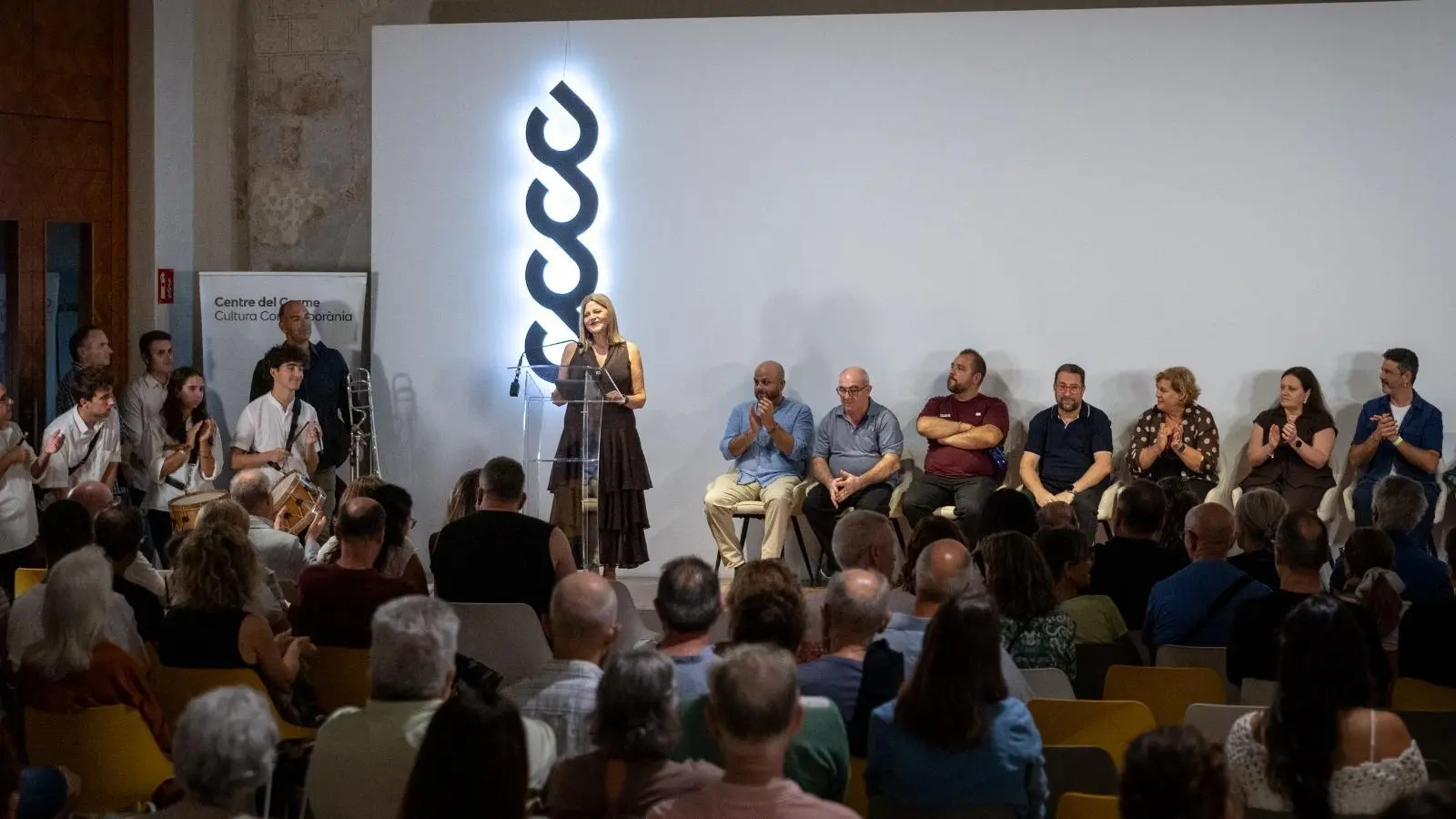 Persones en un acte cultural amb el ‘Cant Valencià d’Estil’ davant l’autoritat de la Generalitat